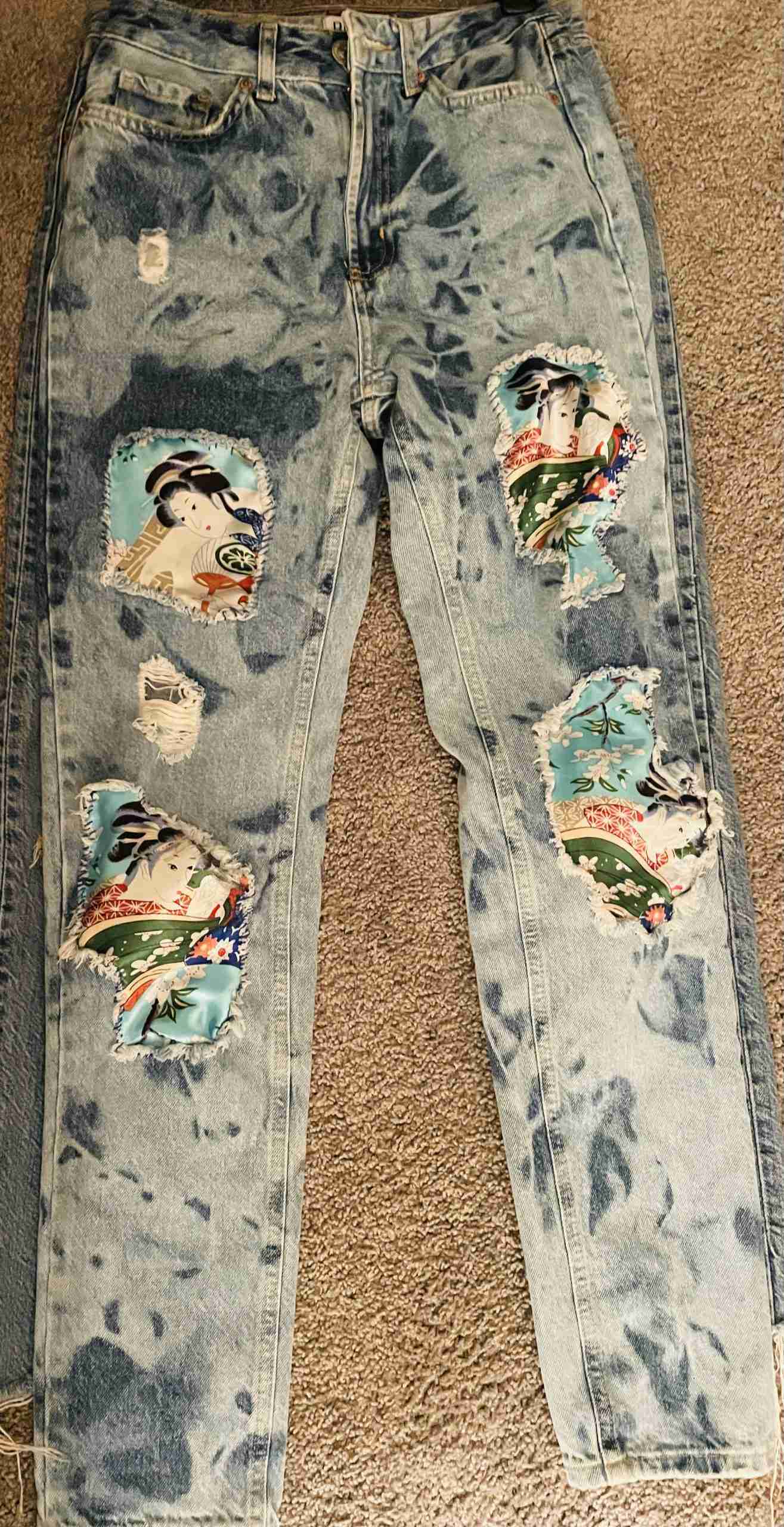 a pair of blue jeans with patches on them.