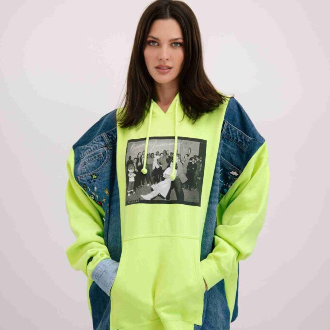 a woman wearing a neon green hoodie with a black and white photo on it.
