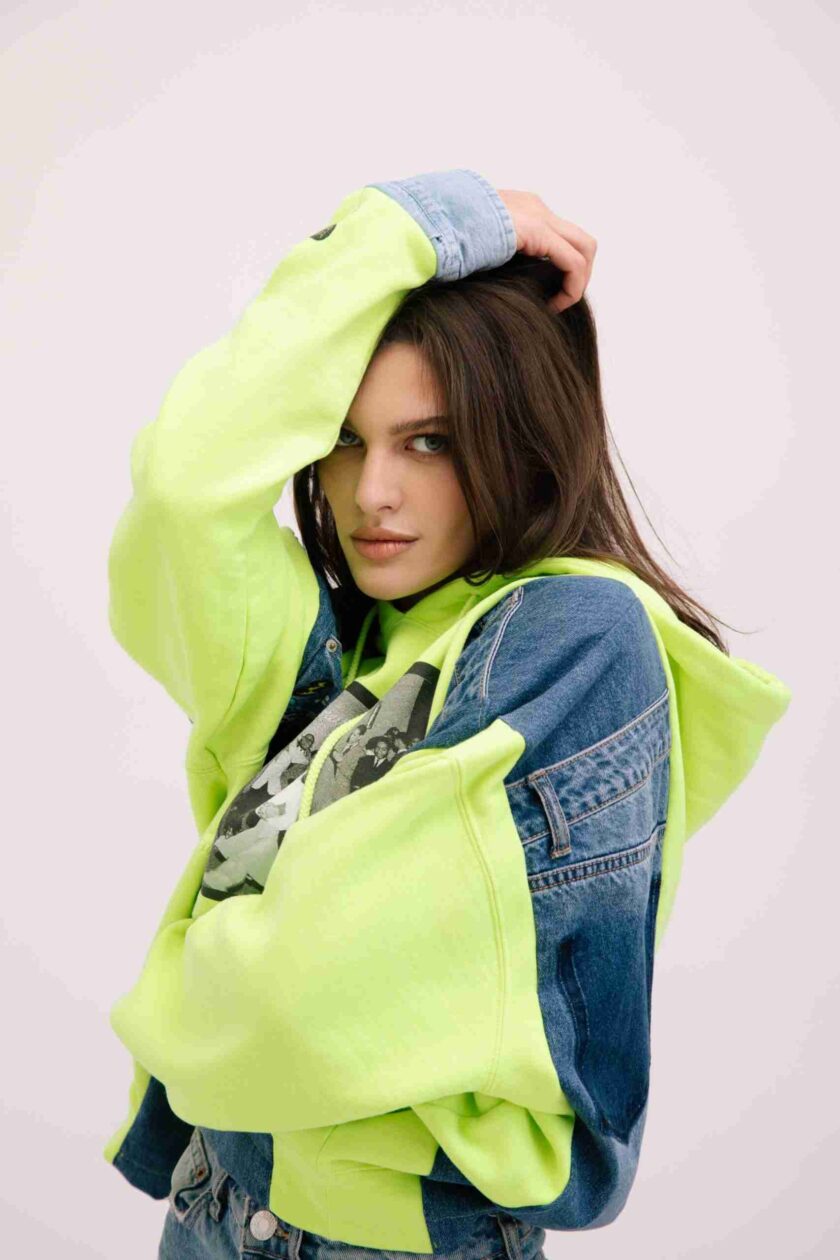 a woman in a neon green jacket is posing for a picture.