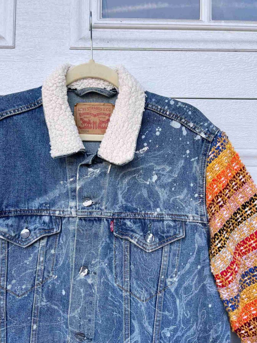 a denim jacket with a patch on the back of it.