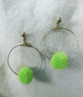 a pair of hoop earrings with green pom poms.