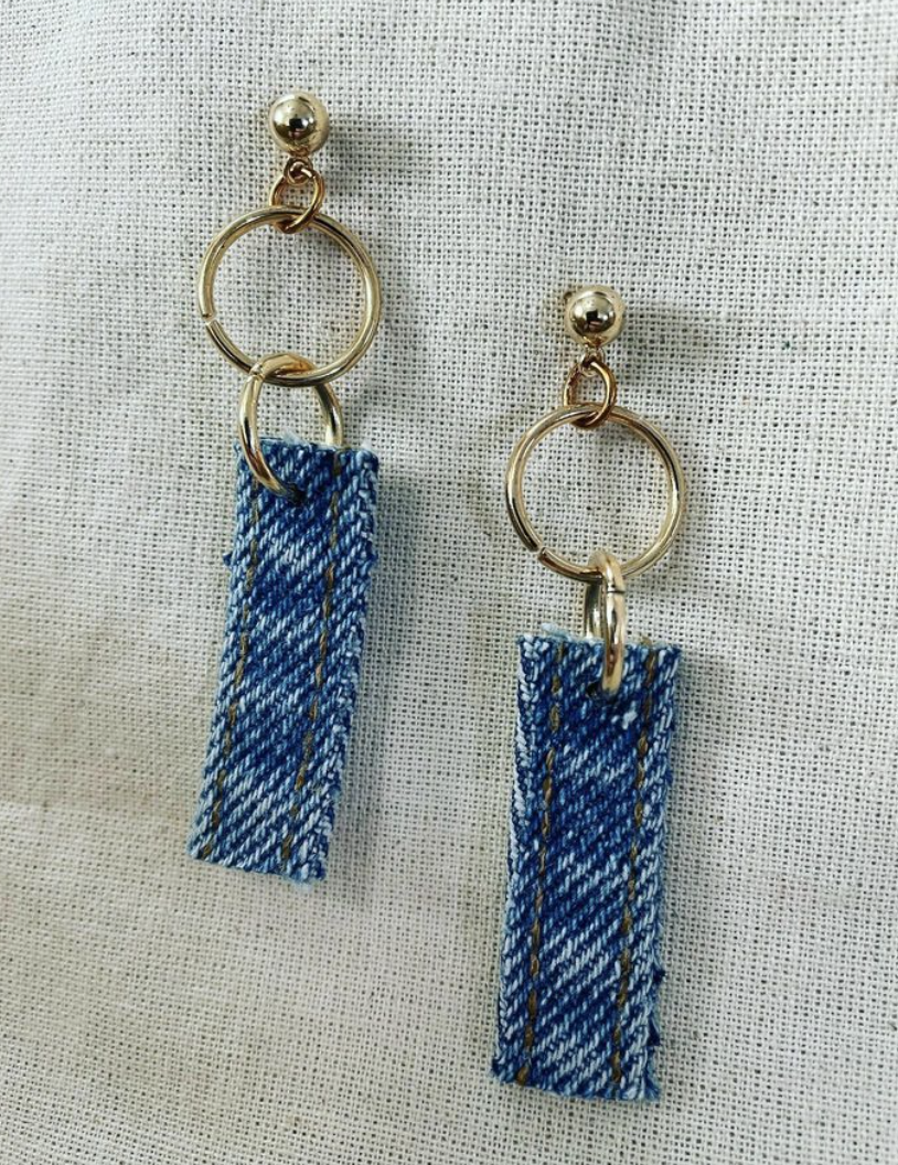 a pair of blue and white earrings on a white cloth.