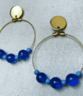 a pair of hoop earrings with blue beads.