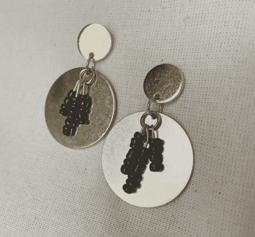 a pair of earrings with black beads hanging from them.