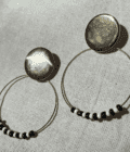 a pair of black and white beaded hoop earrings.