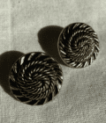 a pair of earrings sitting on top of a table.