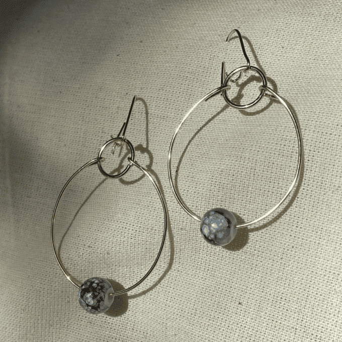 a pair of gold hoop earrings with blue beads.
