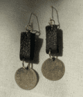 a pair of earrings with a coin hanging from it.