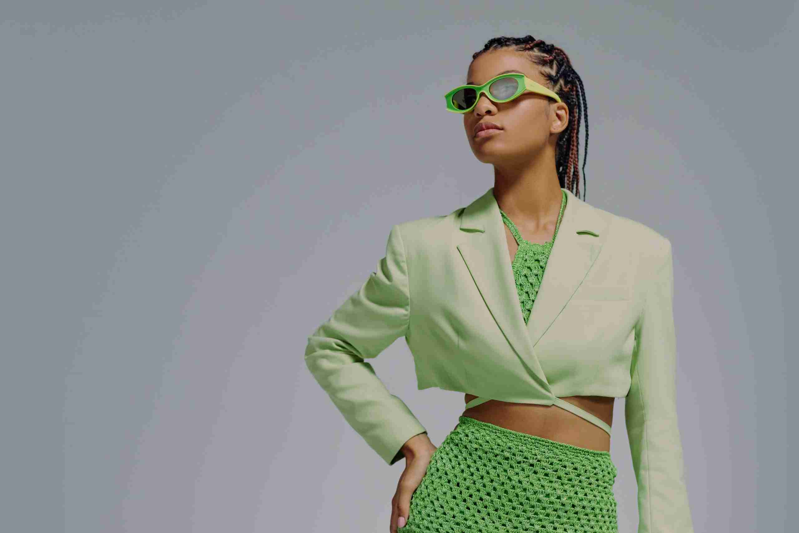 a woman in a green suit and sunglasses.