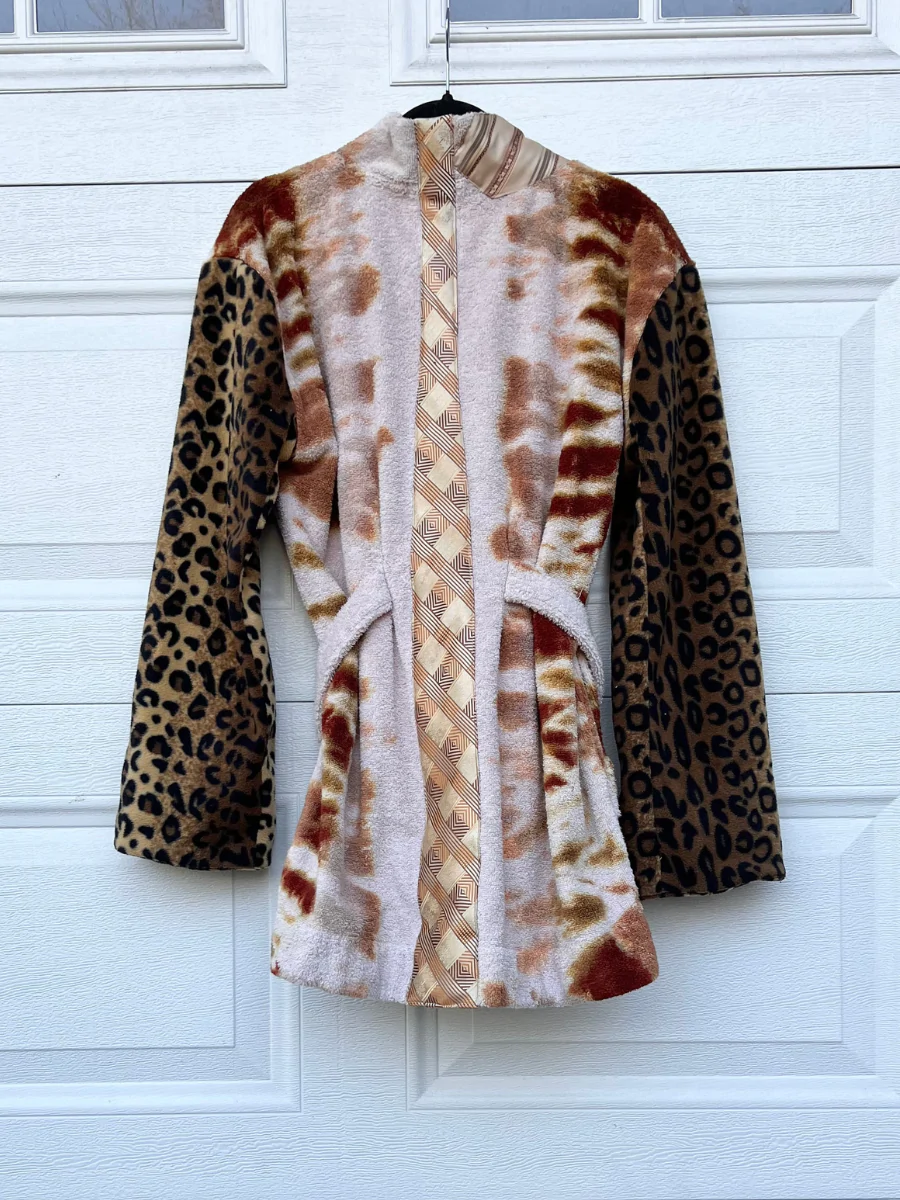 a leopard print coat hanging on a door.