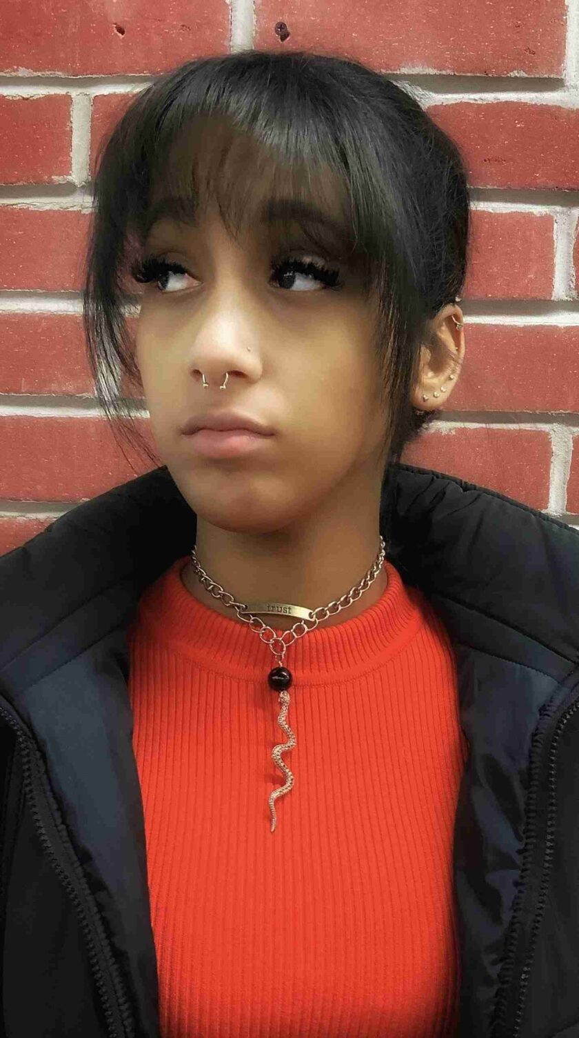 a young girl with a piercing on her nose.