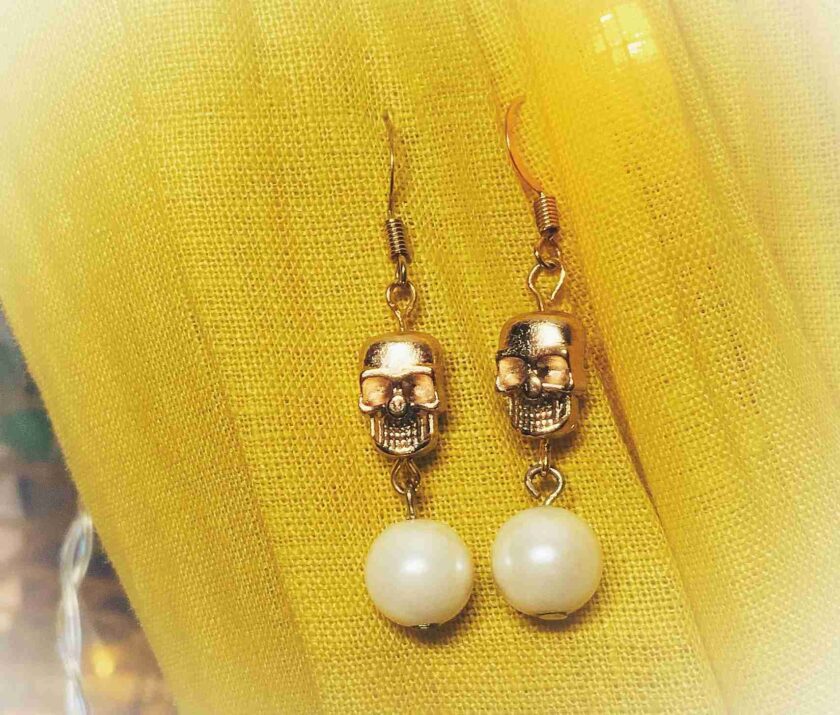 a pair of earrings with a skull on them.
