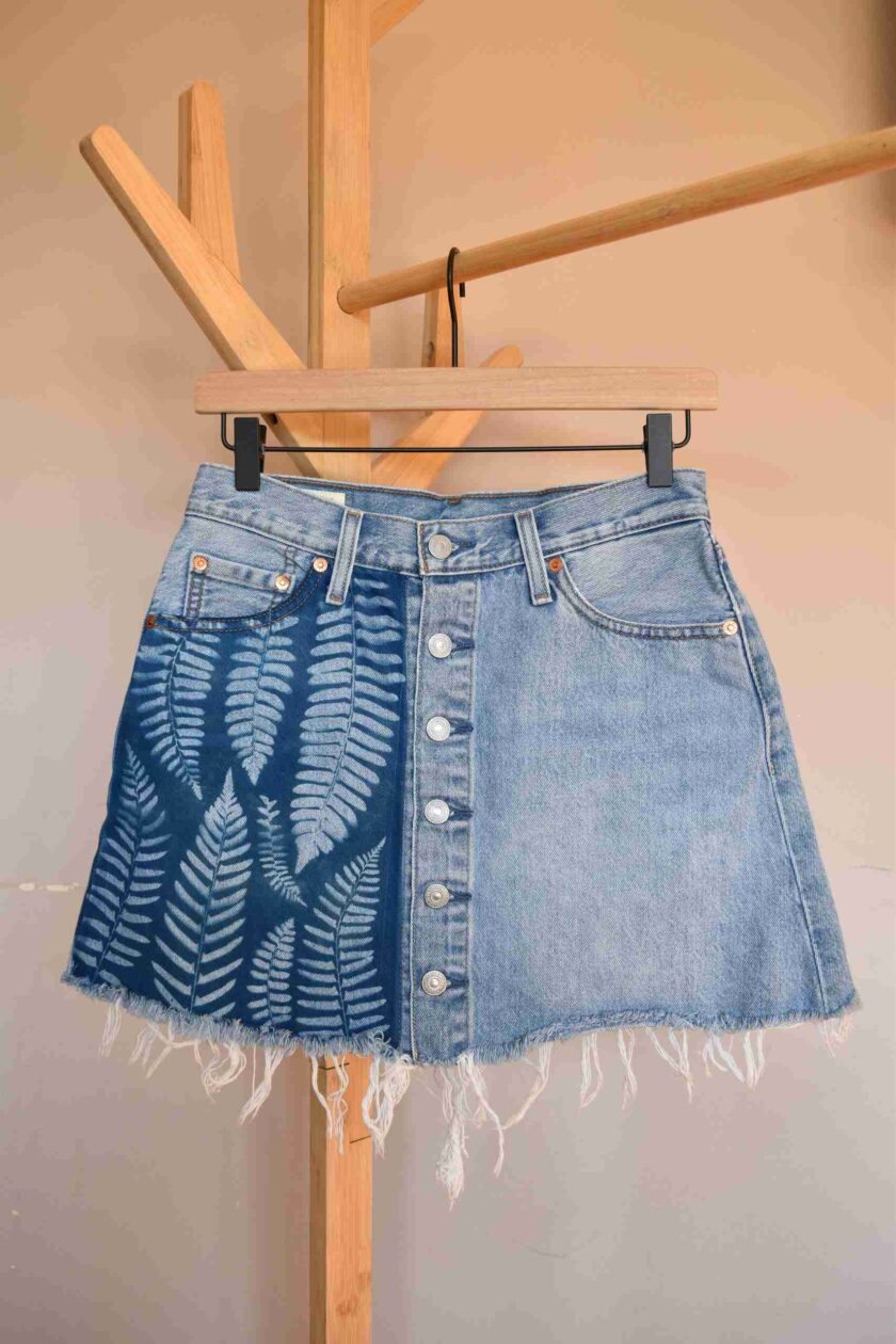 a denim skirt hanging on a clothes rack.