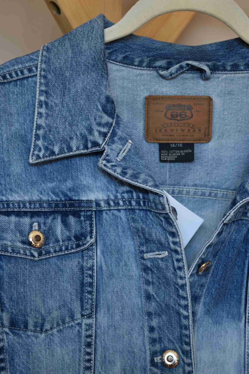 a denim jacket with a leather label on it.
