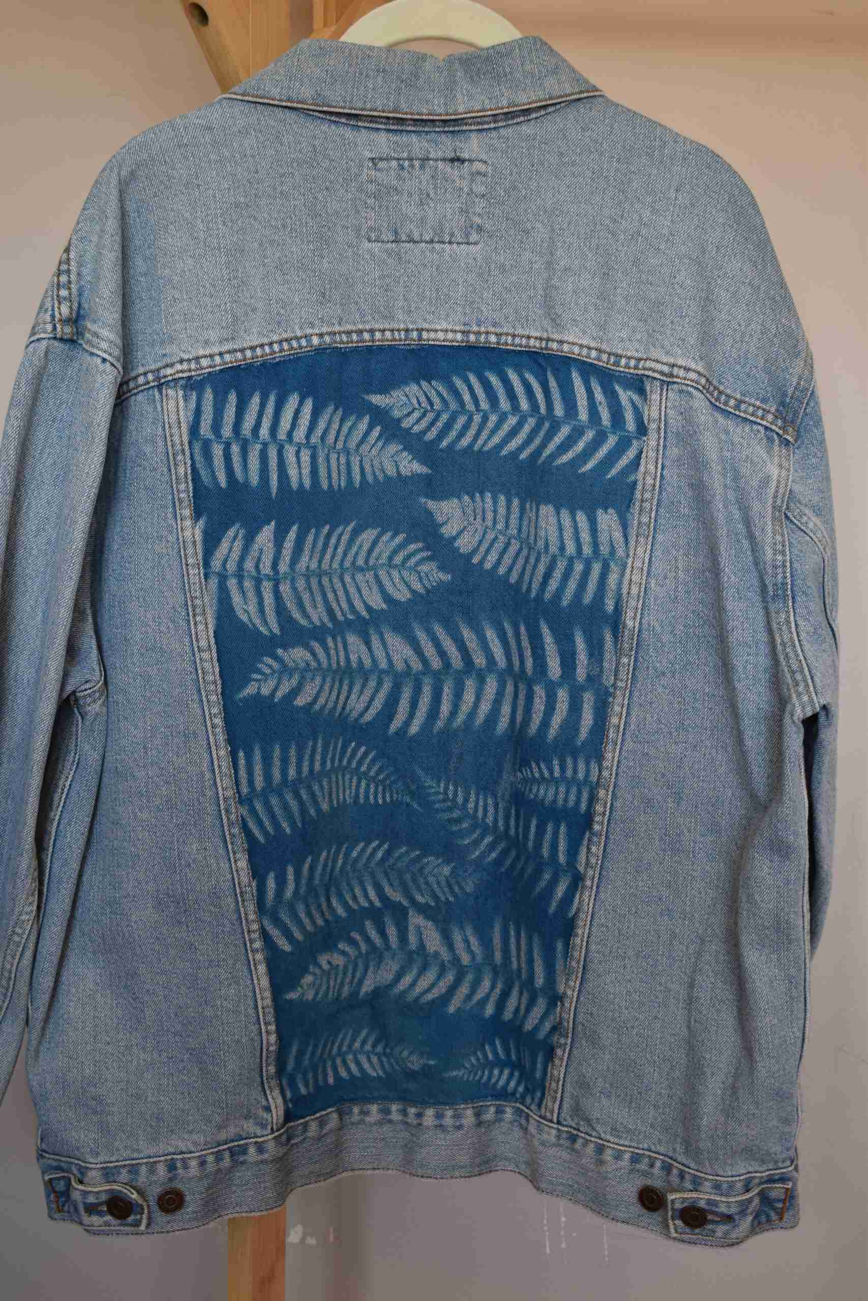a denim jacket with a blue design on it.