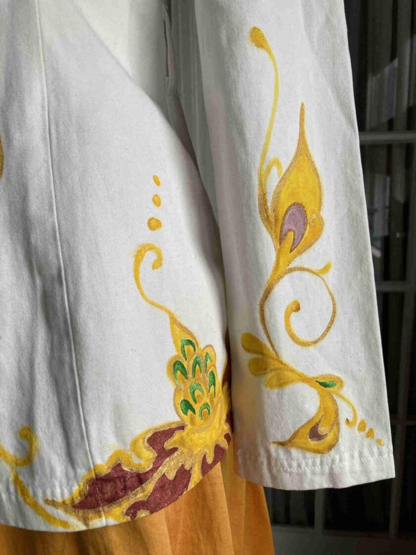 a close up of a white shirt with yellow and red designs.