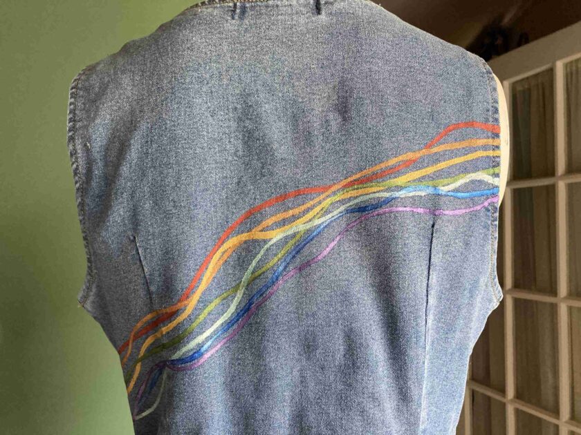 the back of a denim vest with colorful lines on it.