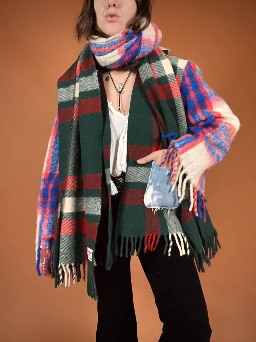 a woman wearing a plaid scarf and black pants.