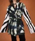 a woman in a black and white tie dye coat.