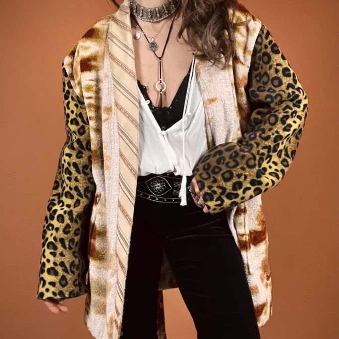 a woman wearing a leopard print jacket and black pants.