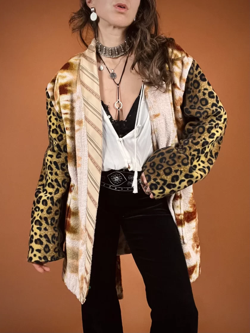 a woman wearing a leopard print jacket and black pants.