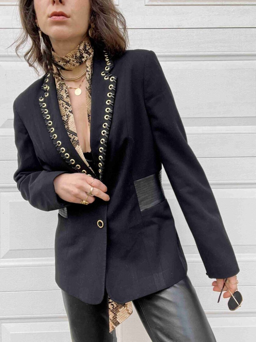a woman in a black blazer and leather pants.