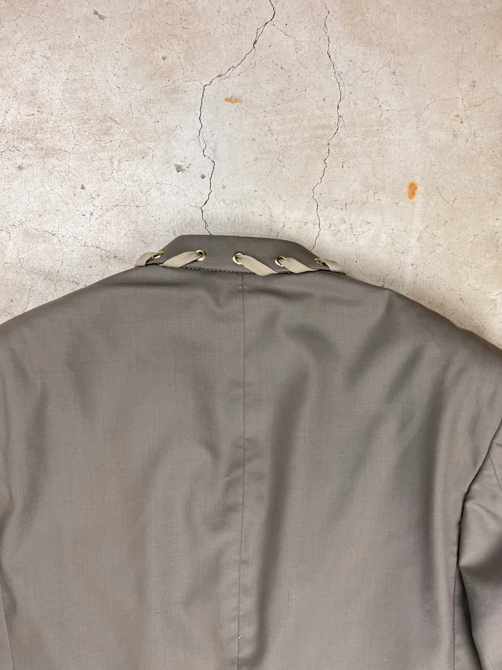 a man's jacket hanging up against a wall.