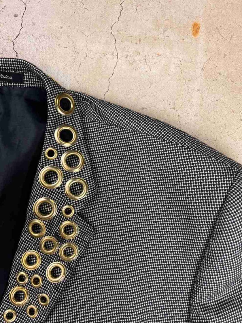 a black and white jacket with gold buttons.