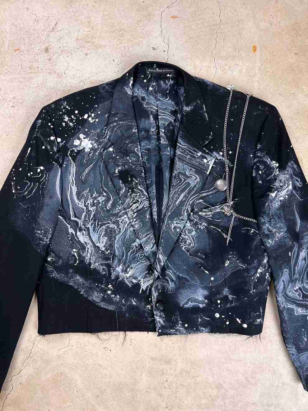 a black jacket with white paint splattered on it.