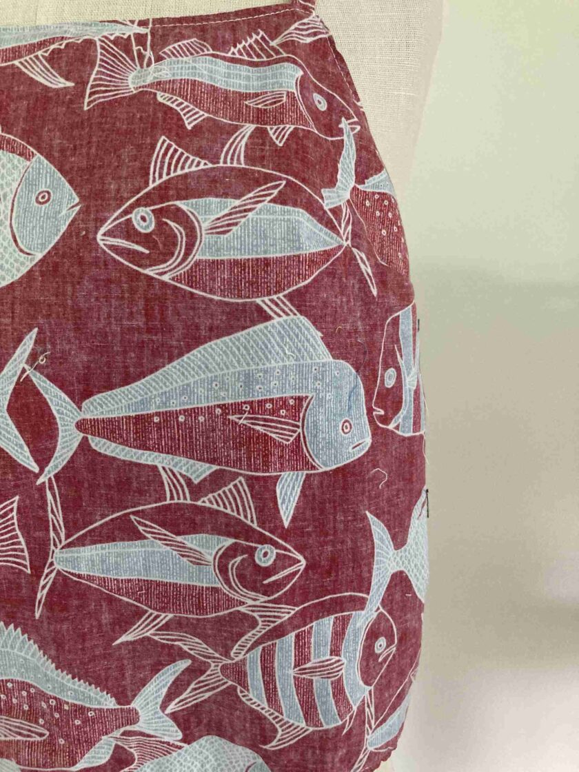 a red and white pillow with fish on it.