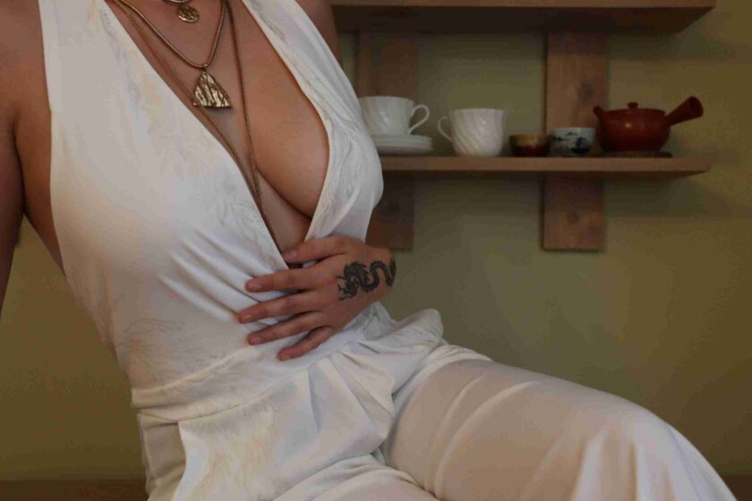 a woman with a tattoo on her chest sitting in a chair.