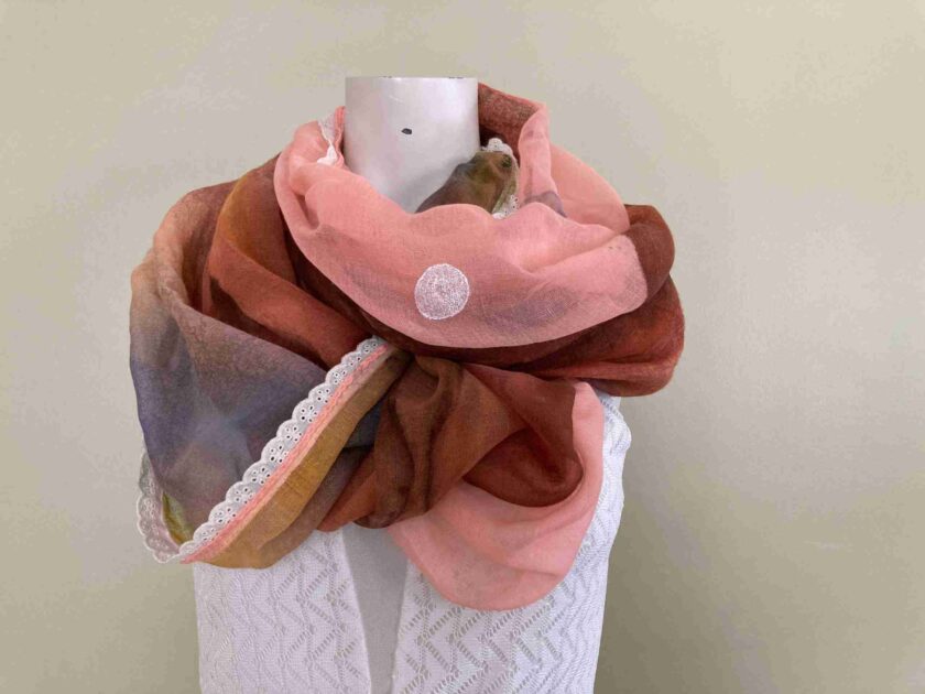 a pink and brown scarf on a mannequin.