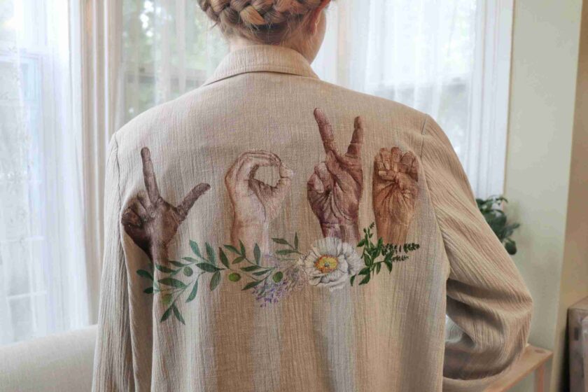 a woman wearing a jacket with hand prints on it.