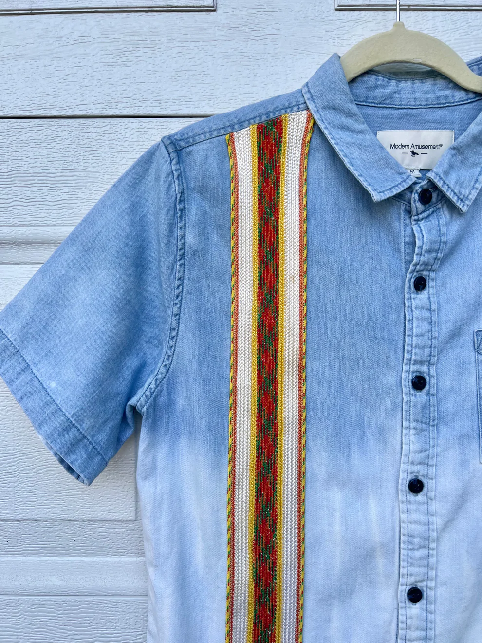 a blue shirt with a colorful stripe on it.
