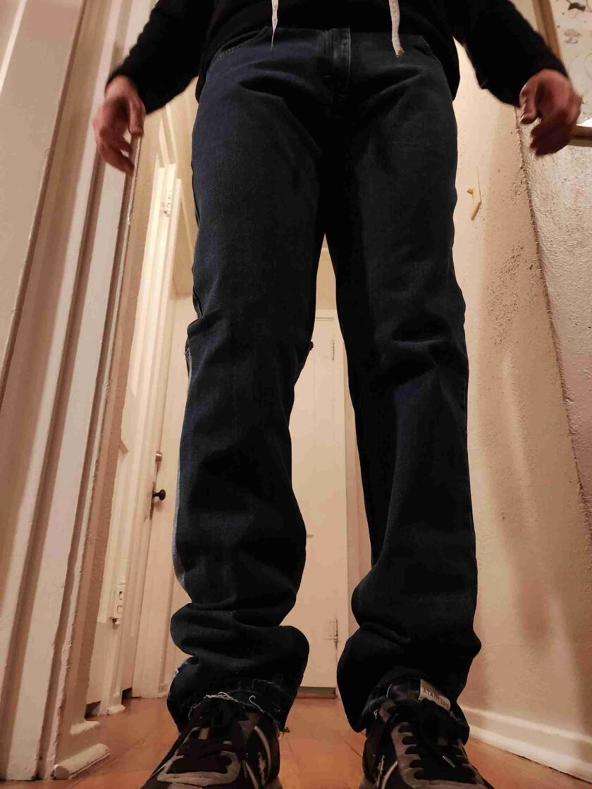 a man standing in a hallway with his hands in his pockets.