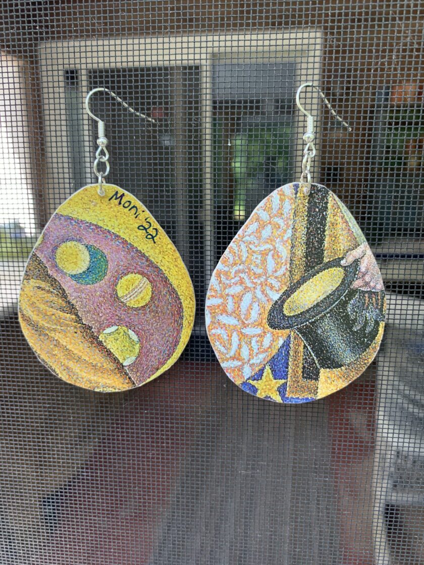a close up of two earrings on a window sill.