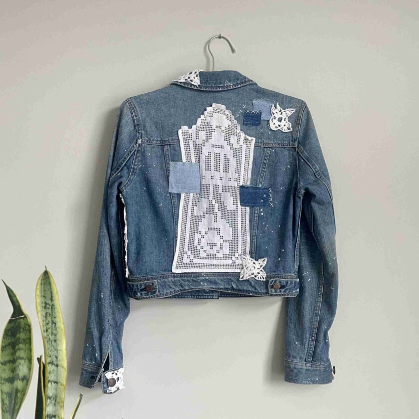 a denim jacket hanging on a wall.