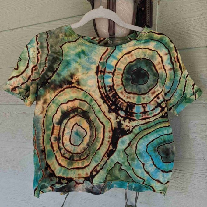 a t - shirt hanging on a wall with a hanger.