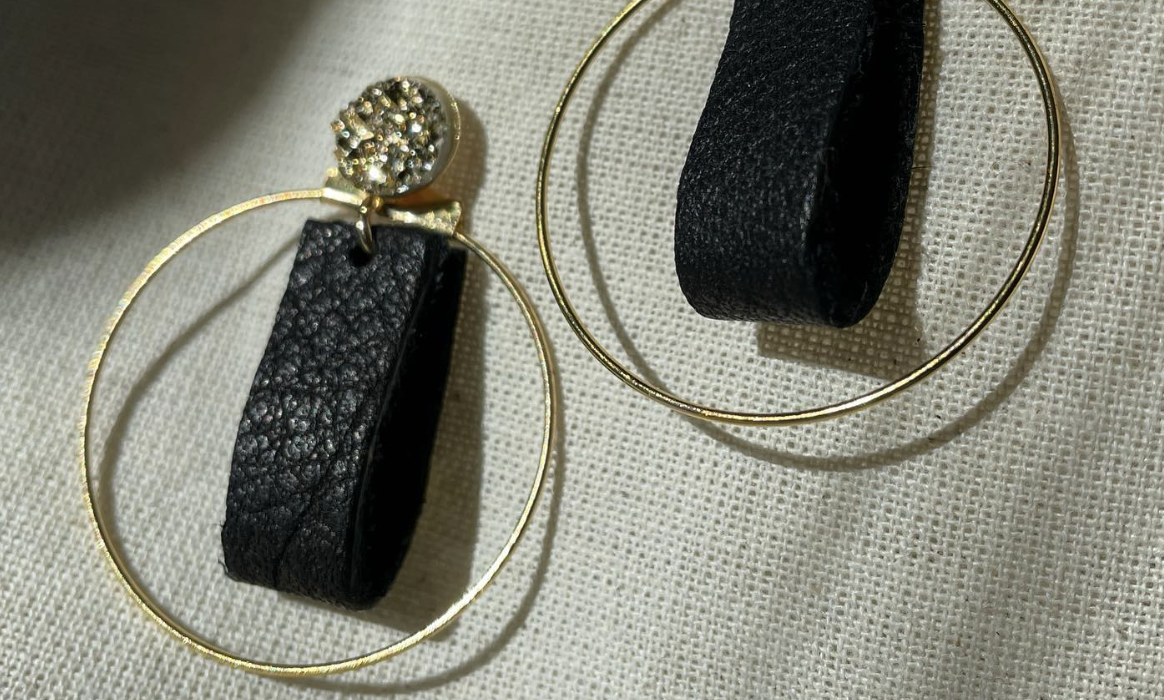 a pair of black leather and gold hoop earrings.