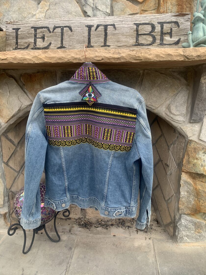 a denim jacket hanging on a stone fireplace.