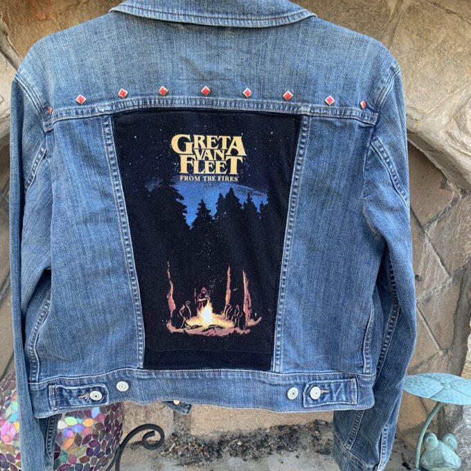 A Greta Van Fleet Denim Jacket with a picture of a campfire on it.