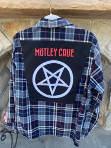 A Motley Crue flannel long sleeve shirt with a pentagramil on it.