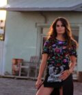 a woman wearing a Beaded sequin short sleeve top standing in front of a building.