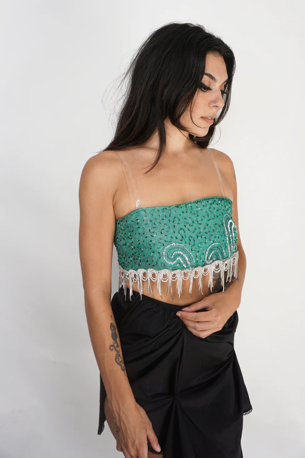 a woman wearing a Vintage Turquoise Shimmer and Crystal Fringe Bra Top and black skirt.