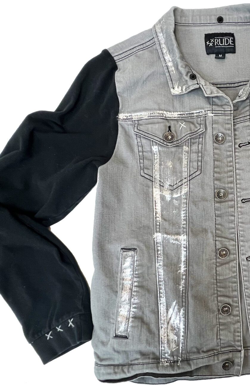 A RUDE eye gray denim jacket with black sleeves and a white shirt.