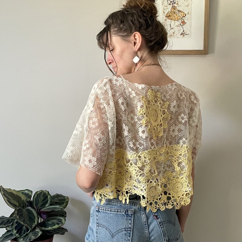 A woman standing in front of Boxy Cream Lace Top w/ Crochet Trim.