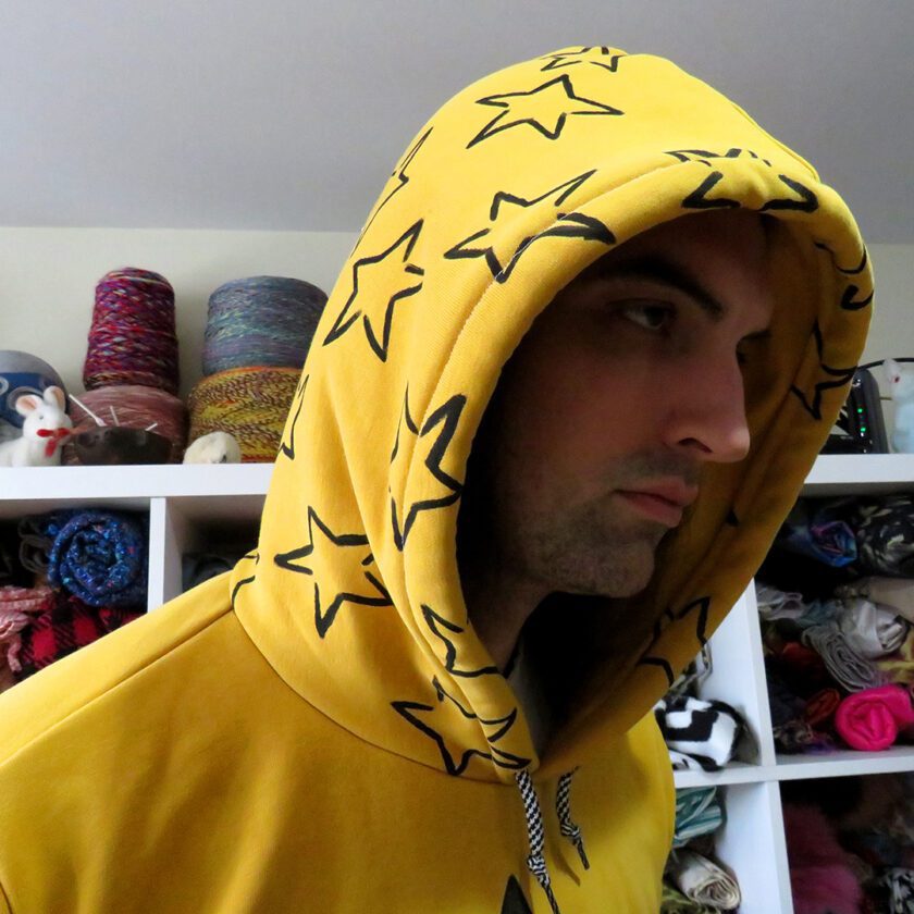 A man wearing the Yellow Star Hoodie (Large).