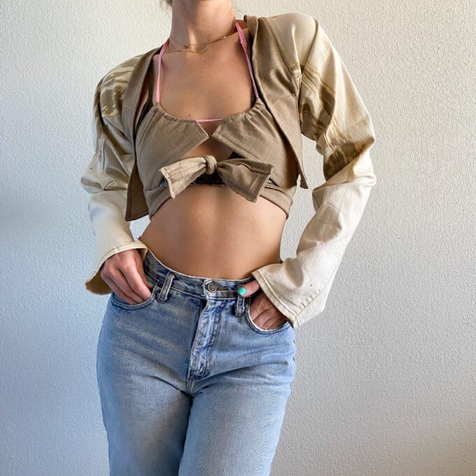 a woman in a 1of1 vanilla caramel dip bolero jacket posing for a picture.
