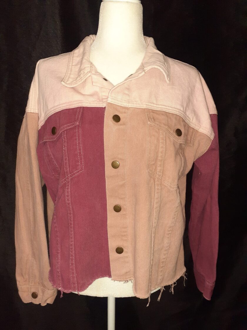 A white mannequin with a Skull & Flowers Frida Kahlo inspired pink color block denim jacket Large on top of it.