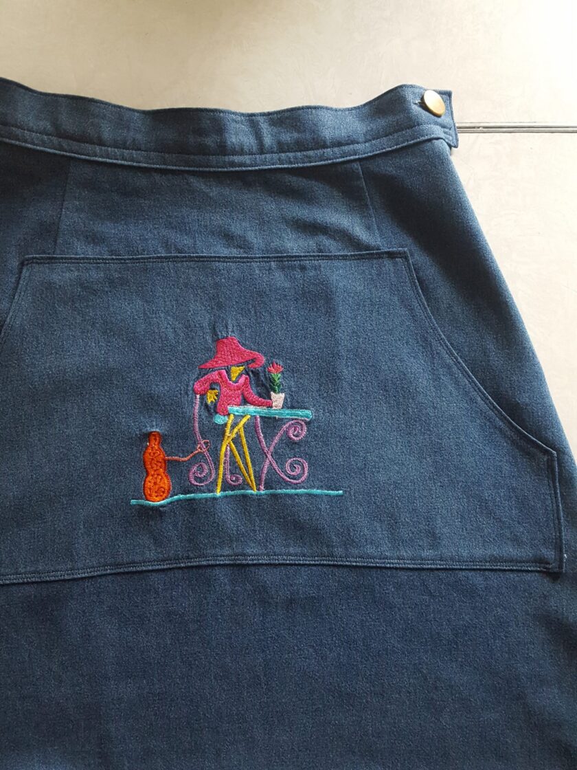 An Embroidered Dark Wash Kangaroo Pocket Mini Skirt with a picture of a cat on it.